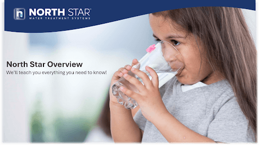 A young girl drinking out of a glass of water