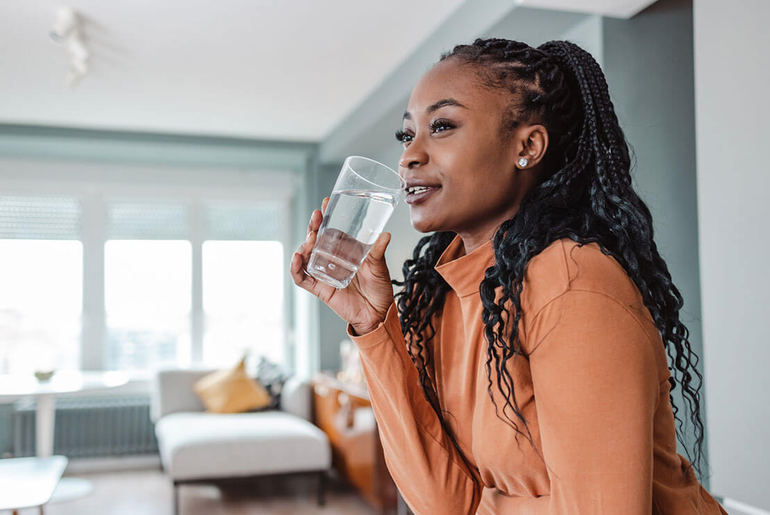 A woman about to drink a glass of water